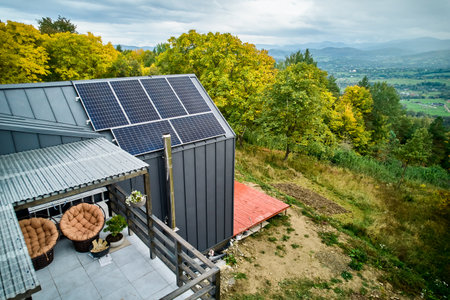 New modern house cottage with solar photovoltaic panel system on roof. Aerial view. Concept of alternative, renewable energy and home autonomy.の写真素材