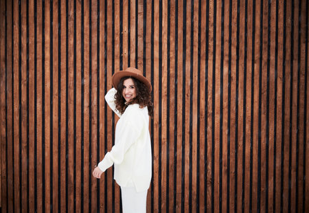 Curly young woman tourist enjoying winter holidays in new cottage.の写真素材