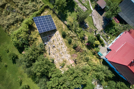 Aerial view of workers installing photovoltaic solar panels to high steel platform in field at sunny day. Concept of alternative energy.の写真素材