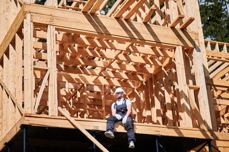 Architect is on construction site of wooden frame two-story house. Concept behind it is modern and environmentally friendly construction.の写真素材