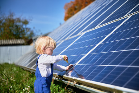 Boy learning how does solar panel work. Small kid interested in using different tools. Curious boy helping to tighten the screw.の写真素材