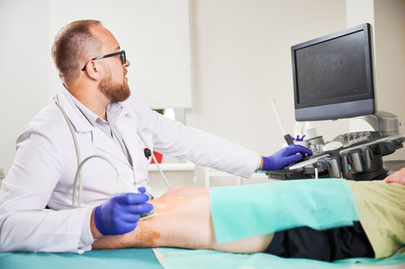 Doctor making ultrasound diagnostics, patient lying on couchette. Male specialist wearing uniform and glasses, looking at screen. Concept of medicine and healthcare.の写真素材