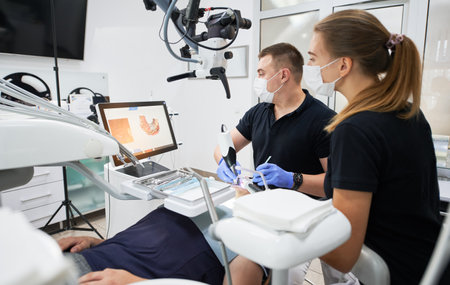 Dentist scanning patients teeth with modern machine for intraoral scanning. Digital print of patients teeth is on big screen. Modern high precision technologies. Concept of modern dentistryの写真素材