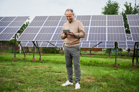 Young investor calculating his future profit from investments in green energy. Alternative energy resources and life improvement. Male with calculator on background solar panel.の写真素材