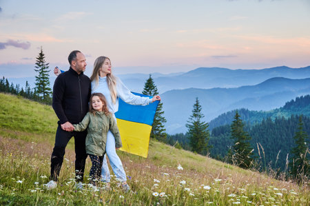 Lovely Ukrainian family resting in mountains. Male adult and his wife standing with their child. Carpathian mountains landscape.の写真素材