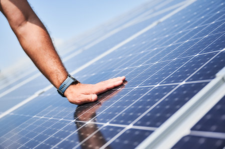 Engineer checking an operation of just installed solar battery. Close up view of hand on PV panel. Concept of reneweble energy.の写真素材