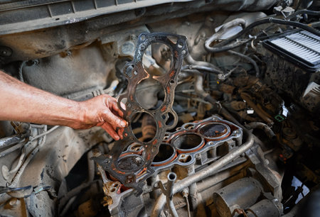 Close up of worker, repairman, mechanic fixing, repairing car. Hardworking man holding dirty steel detail, equipment, working in garage. Concept of repairing, fixing car.の写真素材