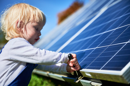 Boy learning how does solar panel work. Small kid interested in using different tools. Curious boy helping to tighten the screw.の写真素材
