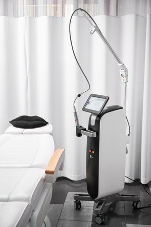 Modern cosmetology equipment for skincare rejuvenation treatment and salon chair in cosmetologist cabinet. Radiofrequency microneedling device for collagen induction therapy in beauty clinic.の写真素材