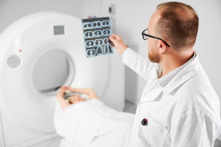 Medical computed tomography or MRI scanner. Close up of doctor holding and examining results of MRI. Woman patient lying on couch. Concept of medicine, healthcare and modern diagnostics.の写真素材