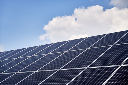 Big solar farm giving large amount of renewable energy. Dark blue PV panels taking energy from sun. Concept of innovations in green energy industry.の写真素材