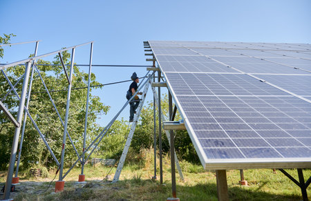 Welder climbing up on staircase for welding. Installing solar panels. Concept of renewable and...