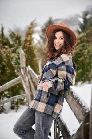 Curly young woman resting in the mountains. Portrait of happy female tourist enjoying winter holidays.の写真素材