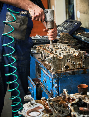 Close up of engineer, mechanic, repairman, worker drilling, holding instrument by hands. Strong man...