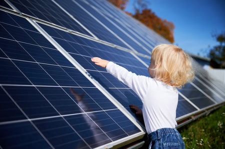 Curious boy interested in how solar panel works. Little child looking at dark blue solar battery. Concept of young generation and alternative energy.の写真素材
