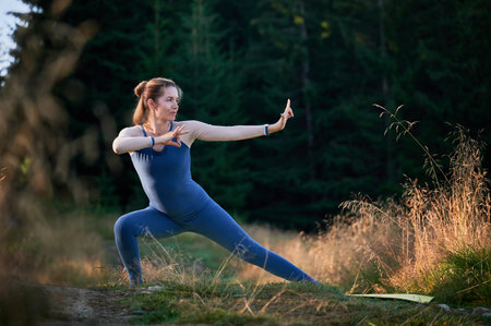 Sporty woman practicing yoga in forest. Middle-aged female exercising early in morning. Female doing sport outdoor.の写真素材