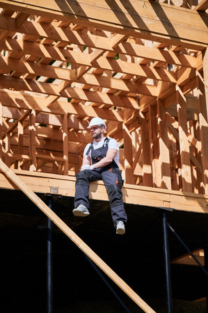 Designer working on wooden frame house construction site. The concept behind it is modern and environmentally friendly construction.の写真素材
