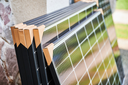 Close-up new solar panels with protective cardboard corners, ready for installation. Renewable energy technology, green living, and the implementation of solar power in residential areas.の写真素材