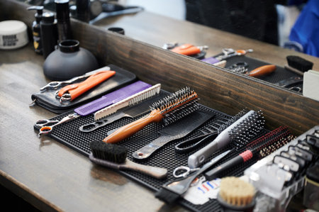 Close up view of hairdressers tools. Cropped photo of barbers equipment on wooden table. Different combs and brushes lying on background of mirror.の写真素材