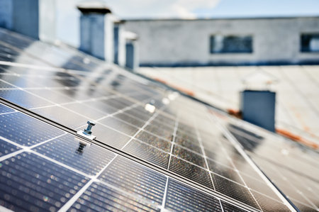 Close up of mounting hardware on solar panel, focusing on the details of the securing mechanism. Bolt and mounting structure against the blurred lines of photovoltaic cells stretching into background.の写真素材
