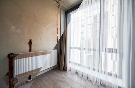 Comparison of apartment flat before and after restoration or refurbishment. Photo collage of old room with large windows and new renovated room with heating radiator, parquet floor and white walls.の写真素材