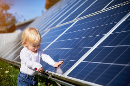 Little child learning how to use tools. Small kid investigateing how does solar battery work. Curious boy interested in repairing.の写真素材