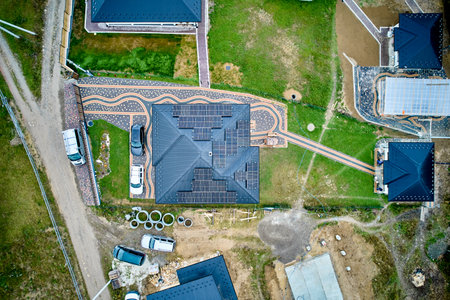 Aerial top view of solar panels on roof. Modern cottage with alternative electricity source. Concept of green energy.の写真素材