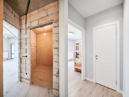 Old apartment with brick walls and new renovated flat doors, children room and elegant interior design. Comparison of apartment before and after restoration. Home renovation concept.の写真素材