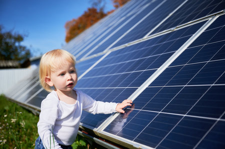 Little boy wondering what solar panel is. Curious child investigating how does solar battery work. Concept of kids and green energetic.の写真素材