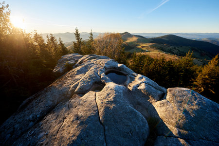 Scenic sunrise at Pysanyi Kamin in Carpathians, Ukraine. Rocky surface in foreground. Breathtaking...