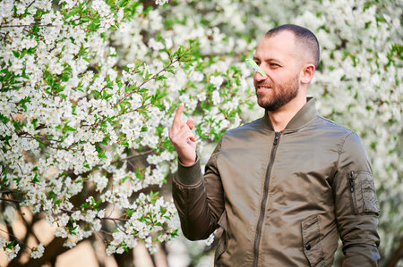 Man allergic suffering from seasonal allergy at spring. Man with clothespin clipped to his nose - symbolic gesture of his inability to breathe due to nasal congestion, showing middle finger gesture.の写真素材