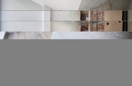 Empty living room with installed heating system before and after restoration. Comparison of old apartment and new renovated flat with parquet floor, radiator and white wall. Home renovation concept.の写真素材