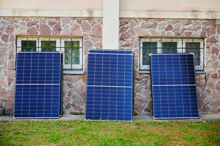 Stack of new solar panels with protective cardboard, ready for installation. Renewable energy,...
