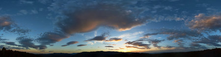 Stunning sunset fills sky with rich hues of blue and orange. Dramatic clouds with hints of pink and...