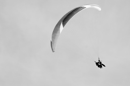 Paragliding in mountains in spring time. Blank space for a text. Black and white picture. Men on the right side. Georgia, Gudauri.の写真素材