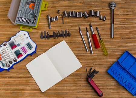 Engeneering tools set on wood background. Assortment instruments for repairman, carpenter, builder. Open notebook with blank pages. Copy space for text. Top view.の写真素材