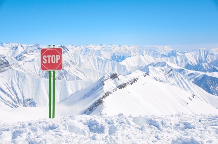 Sign stop on ski resort high in mountains. Place for freeride with powder. Dangerous snowy way or...