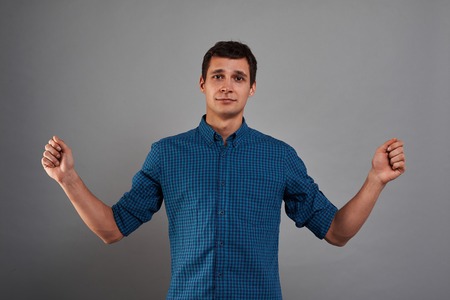 Studio portrait of man with open hands for insert blank banner or product. Quiet emotion on the face. Place for present something.の写真素材