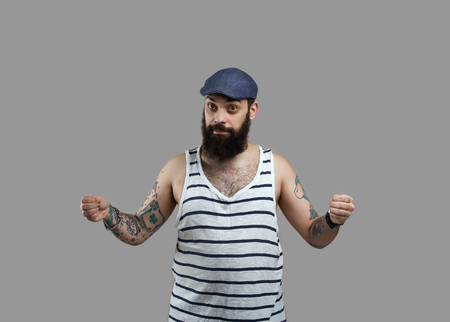 Beard tattooed body man with two open hands for incert advertisind product isolated on grey background.の写真素材