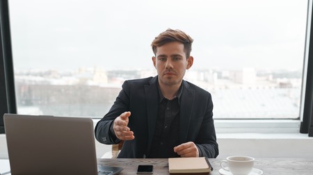 Young businessman ready for the interview and meet job seeker. Recruitment and human resources theme. Chef happy to recruit somebody for a manager vacancy. Boss invite to take place on the chair.の写真素材