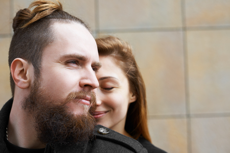 Close up portrait of lovers in city. Man look away and girl with closed eyes feel romantic moment. Happy people faces. Family and relationships concept.の写真素材