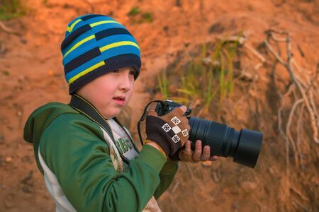 The little boy with the camera in mountainsの写真素材