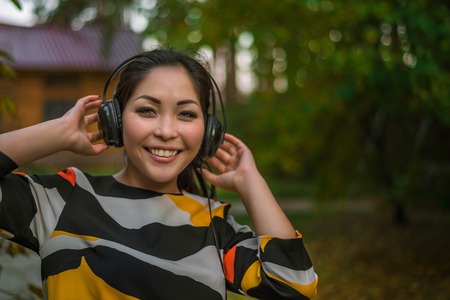 Young beautiful girl listens to music and dances