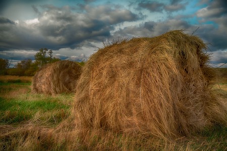 hay stack in a summer field. Beautiful landscape with storm cloudsの写真素材