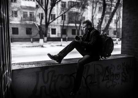 The photographer sits on the panel of arch pass and looks at the streetの写真素材