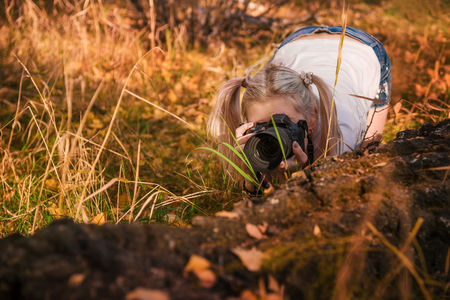 portrait of a beautiful hipster girl with a camera taking photos  in the autumn parkの写真素材