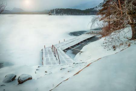 The wooden pier on a frozen lakeの写真素材