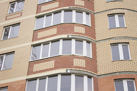 Brick Wall of a high-rise building with plastic windowsの写真素材