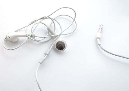 Earphones with knot on the wires, earphone jack, on white background