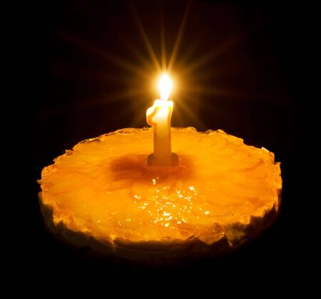 Birthday cake with burning candle symbolizing first anniversaryの写真素材